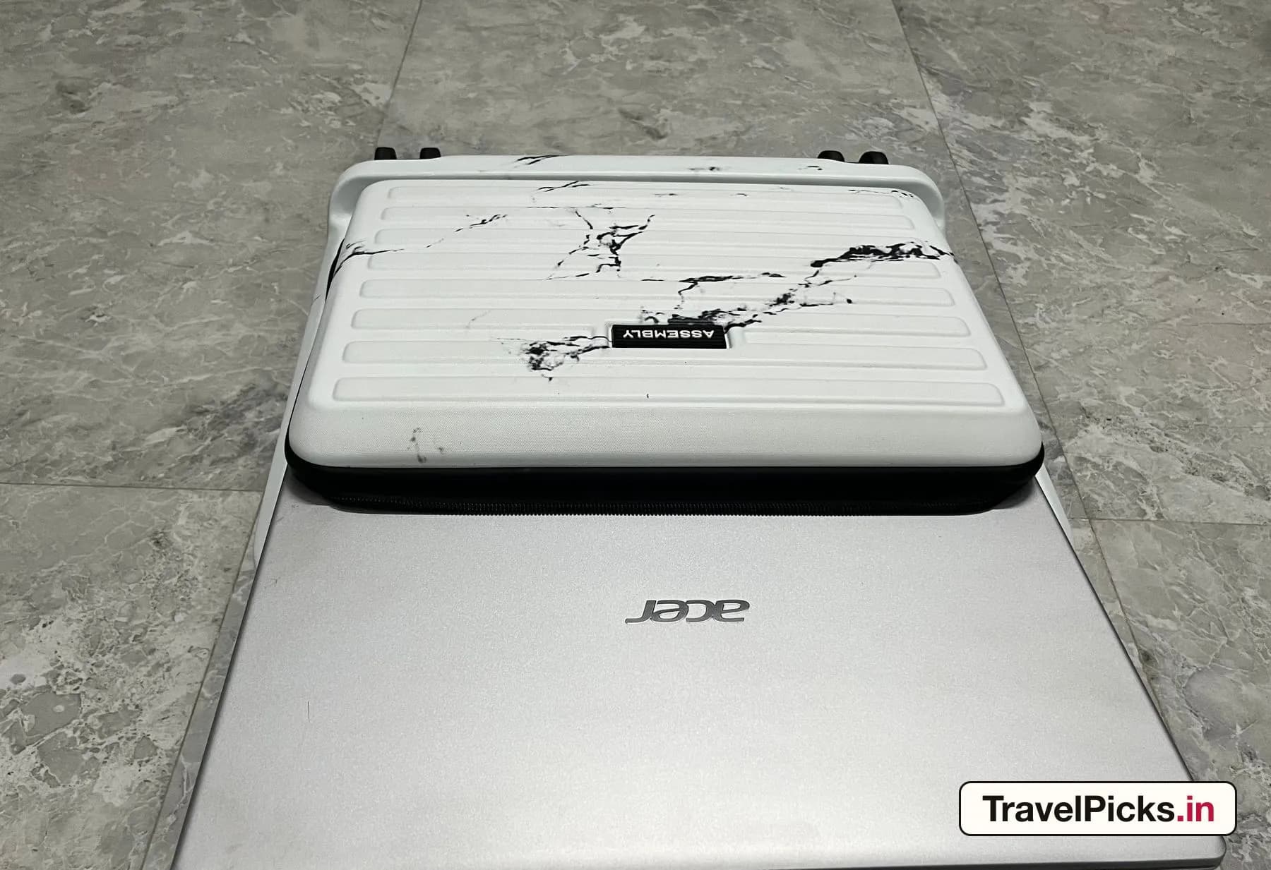 The closed case standing on a 17-inch laptop, which is visibly wider at both ends.